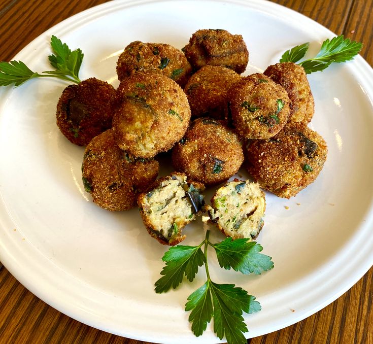 a white plate topped with meatballs and parsley