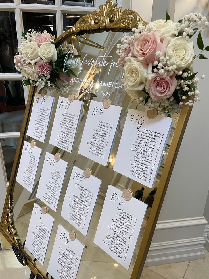 a table with seating cards and flowers on it