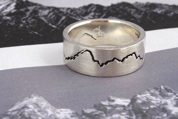 a silver ring with mountains etched on it