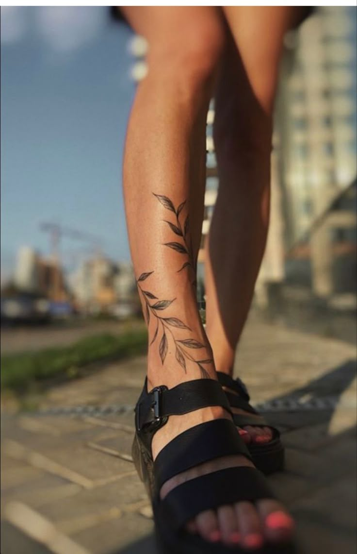 a woman's legs with tattoos on them and her foot in the middle of the photo