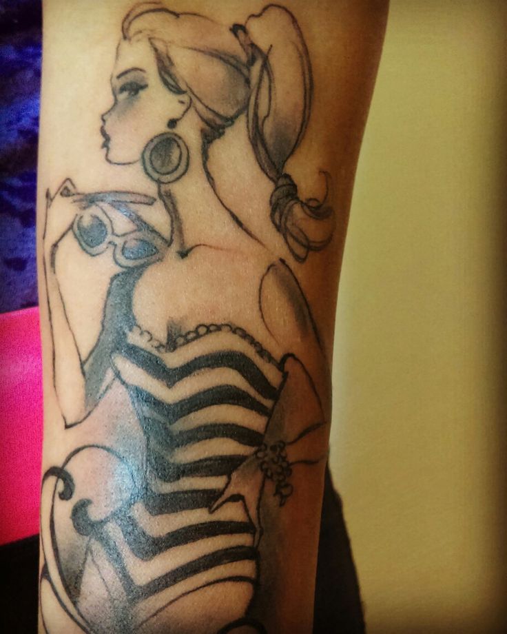 a woman's arm with a black and white tattoo on it