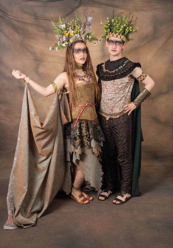 two women dressed in costume posing for a photo together, both wearing flower crowns on their heads