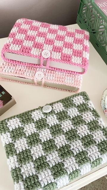 two crocheted purses sitting on top of a table next to each other