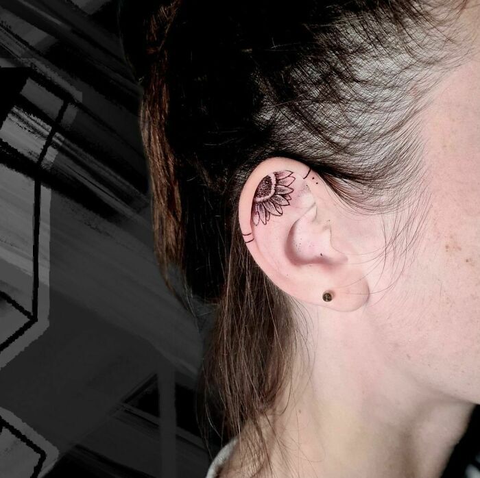 a woman with a tattoo on her left ear