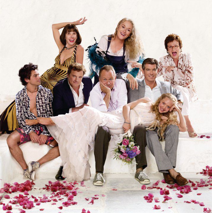 a group of people that are posing for a photo together in front of rose petals