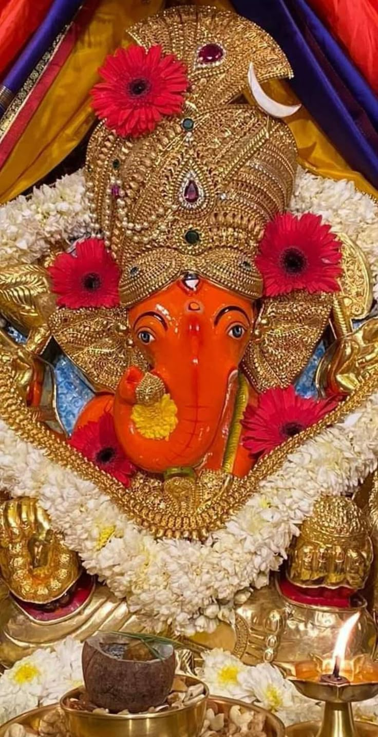 the statue of ganesha is adorned with flowers and garlands on it's head