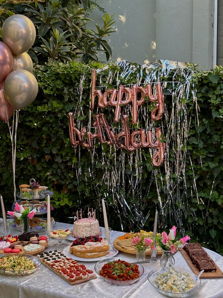 a table topped with lots of food and balloons