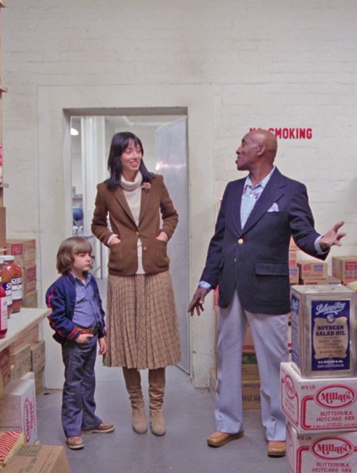 a group of people standing in a room with boxes on the floor and talking to each other