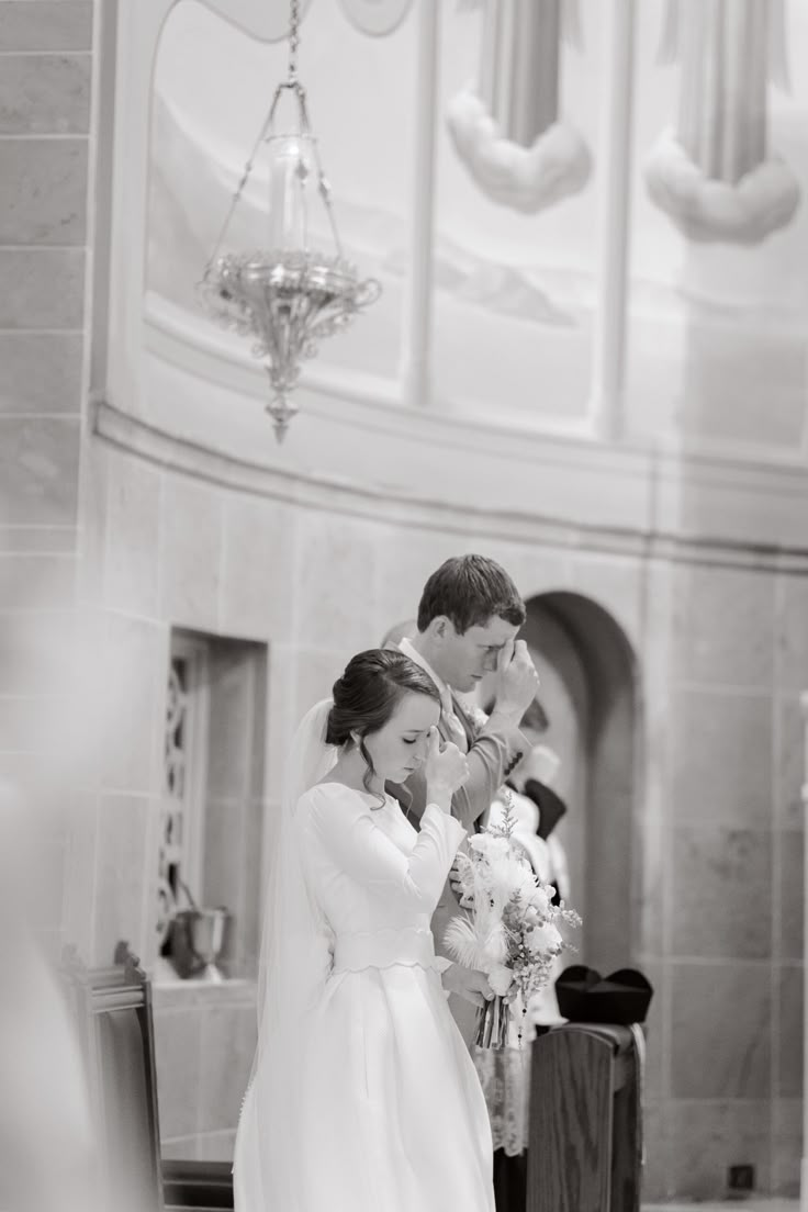 Catholic couple prays at their catholic wedding mass at Holy Rosary Catholic church in Indianapolis Catholic Church Wedding Photos, Catholic Wedding Photos, Catholic Engagement Photos, Latin Mass Wedding, Catholic Wedding Aesthetic, Family At Church, Catholic Wedding Photography, Catholic Wedding Dresses, Small Church Weddings