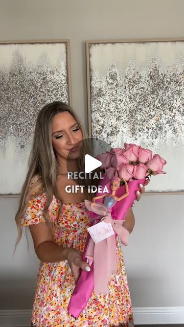 a woman holding flowers in her hand and looking at the camera with an expression that reads, special gift idea