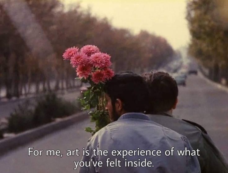 a man and woman sitting on the back of a car with flowers in their hair