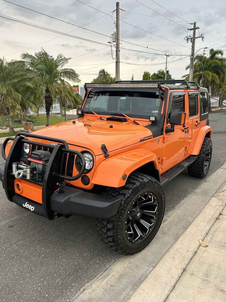 an orange jeep is parked on the street