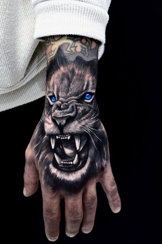 a man's hand with a tattoo on it and a tiger face painted on the palm