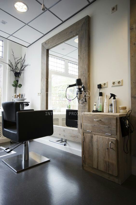 a hair salon with chairs and mirrors in the corner, one chair is facing an open window