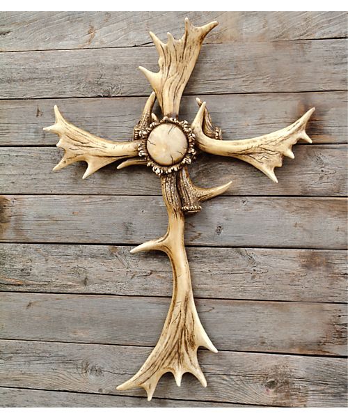 a cross made out of antlers on a wooden wall