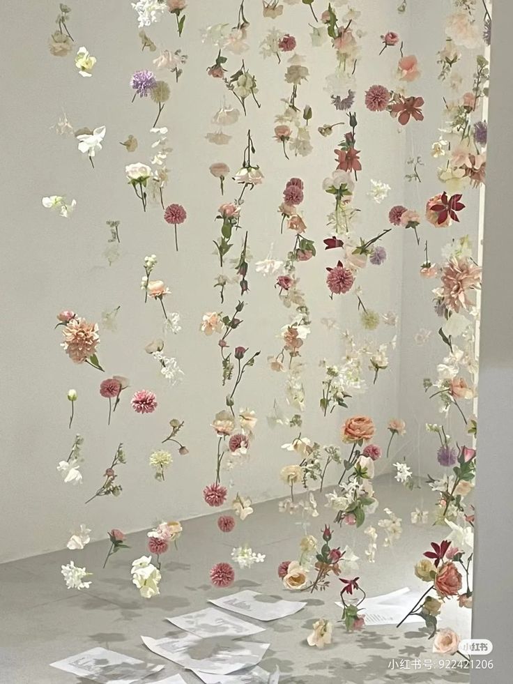 an art installation with flowers hanging from the ceiling