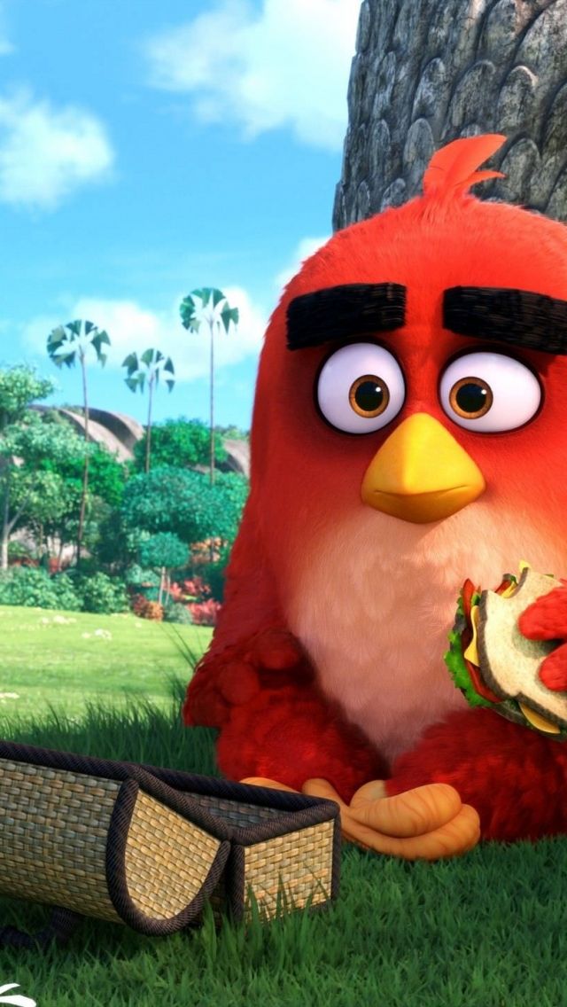 the angry bird is eating a sandwich next to a tree