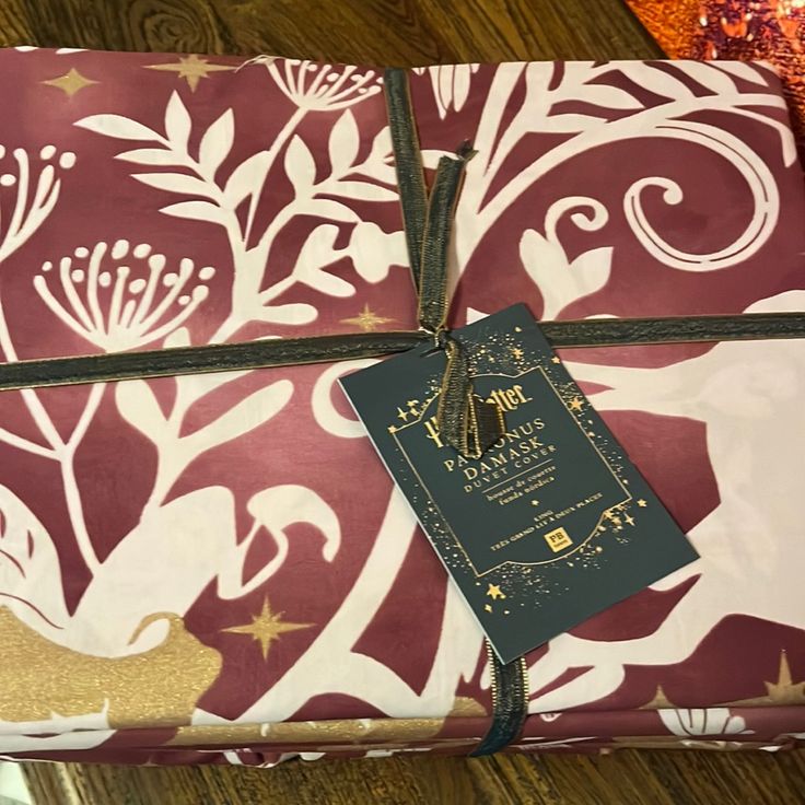 the wrapping paper is wrapped in brown and white floral designs with a gold star tag on it