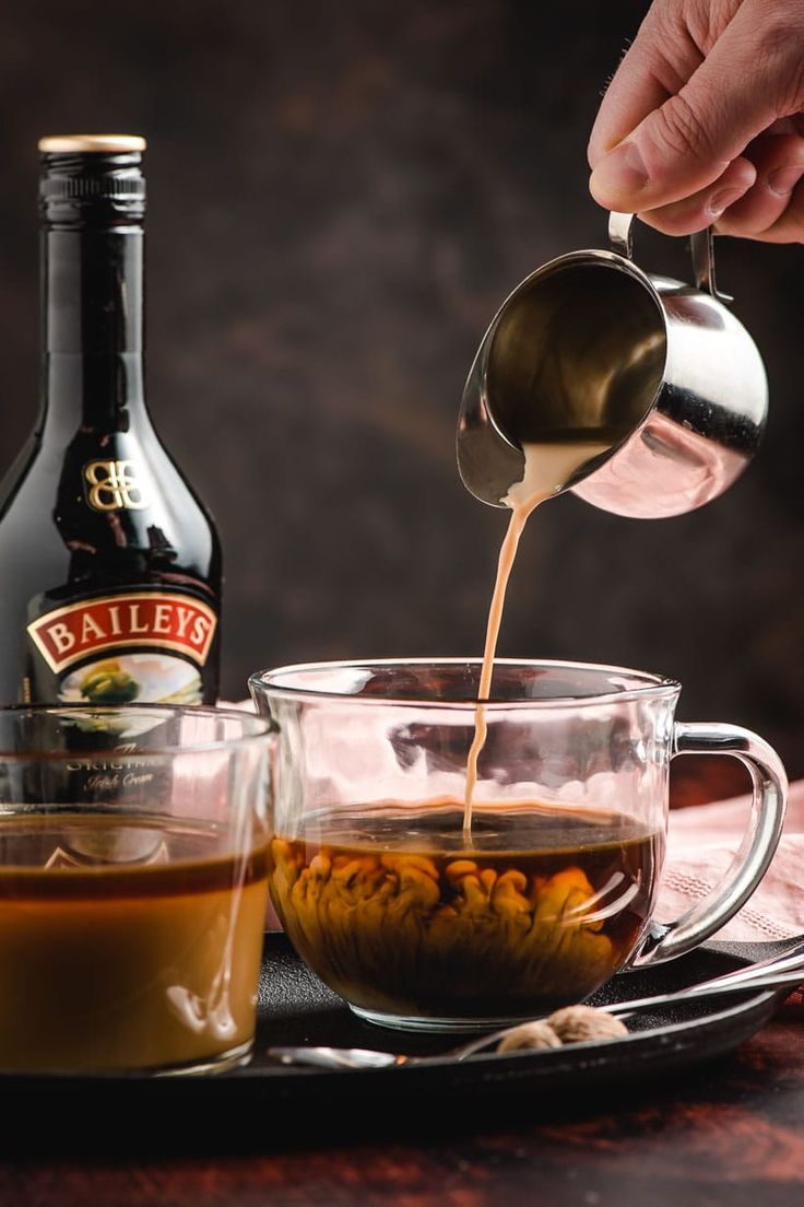 bailey's irish coffee is being poured into a glass cup with caramel syrup