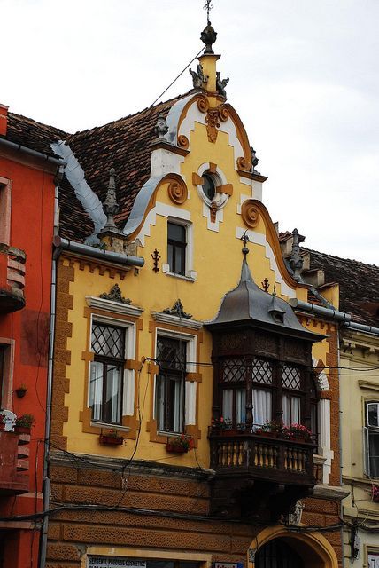 an old building with many windows and balconies on the top floor is painted yellow