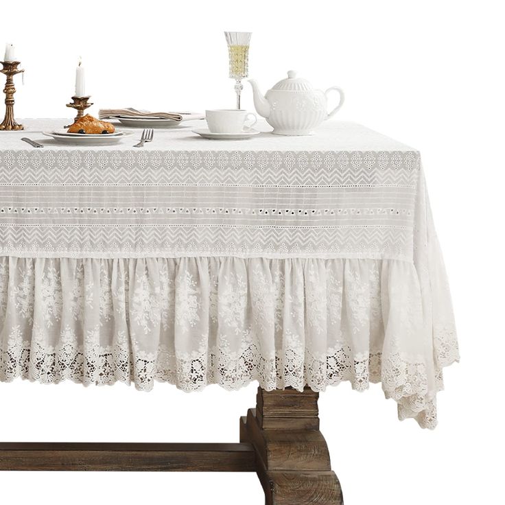 a table topped with a plate of food next to two candles and a tea pot