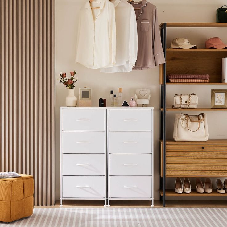 a closet with clothes and shoes on shelves next to a wallpapered striped wall