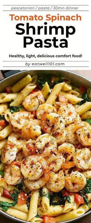 shrimp pasta with spinach and tomatoes in a skillet