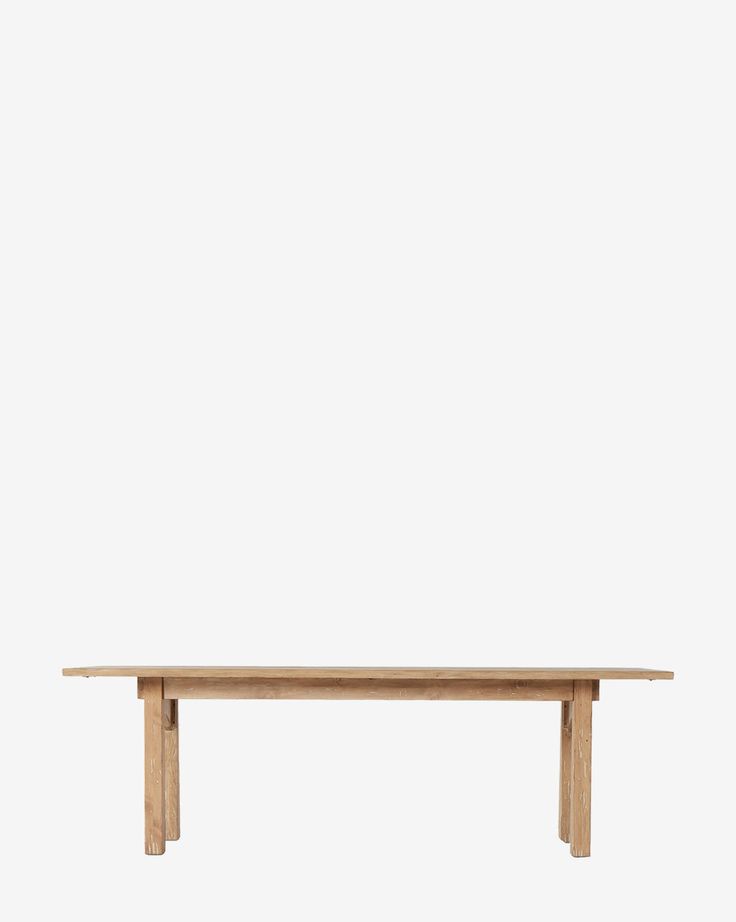 a wooden table sitting on top of a white wall