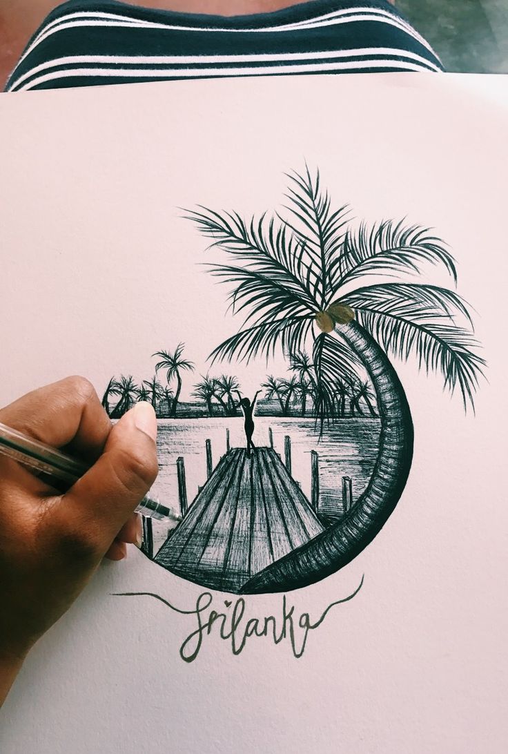 a person is drawing a palm tree on a piece of paper