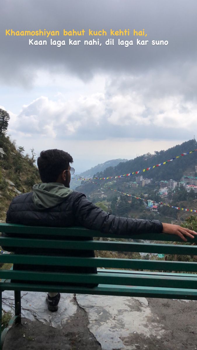 a man sitting on top of a green bench