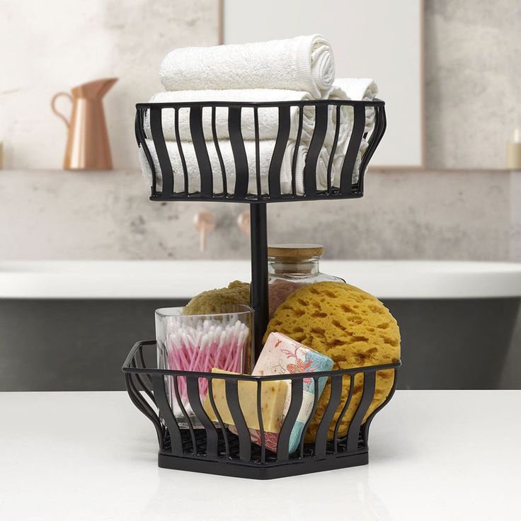 a basket with towels and other items in it on a counter top next to a bath tub