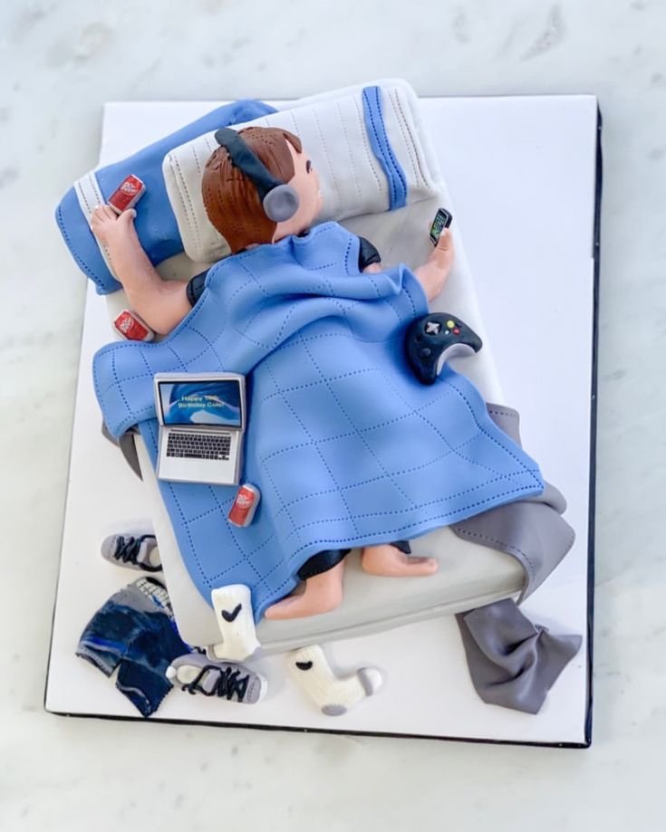 a cake shaped to look like a person laying in bed with headphones on top of it