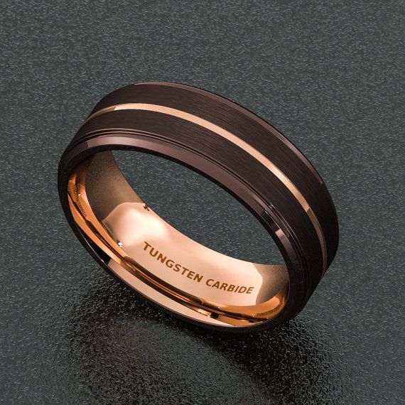 a black and gold wedding band with the words tunsten cambridge engraved on it