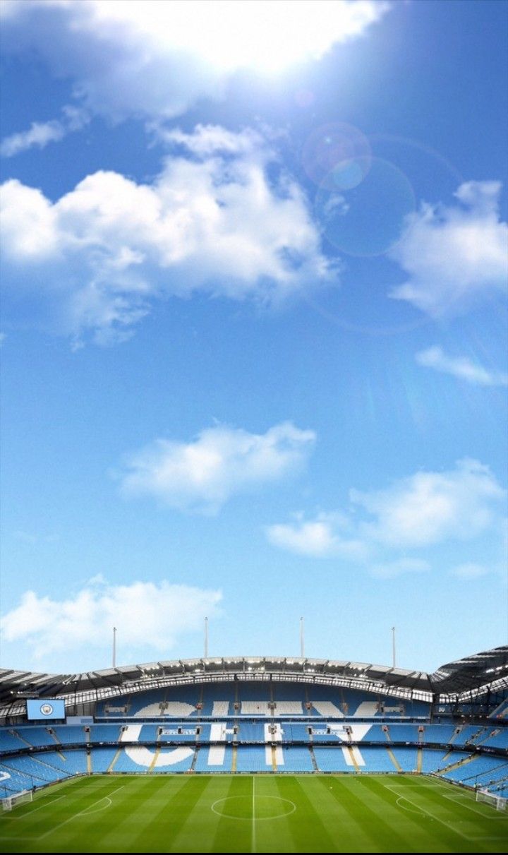 an empty soccer stadium with blue sky and clouds