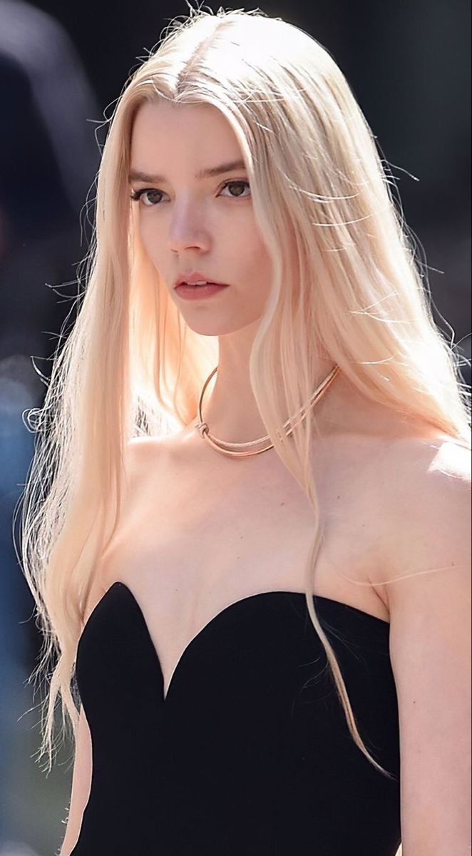 a woman with long blonde hair wearing a black dress