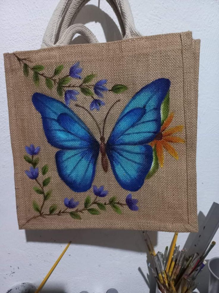 a blue butterfly painted on a burlock hanging from a wall next to other items