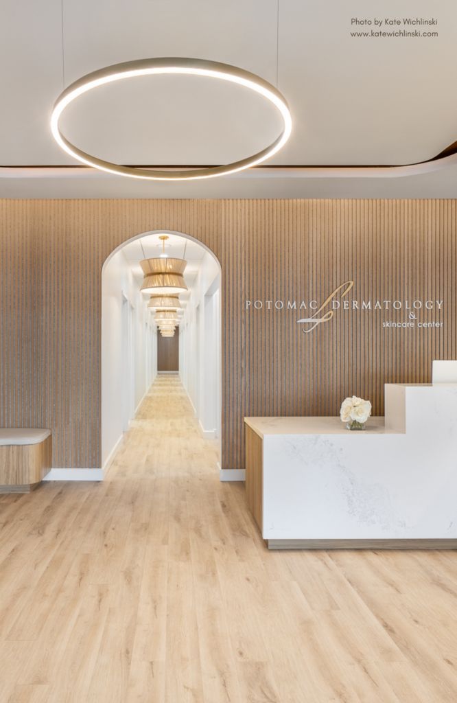 the entrance to an office building with wooden floors and white marble counter tops on each side