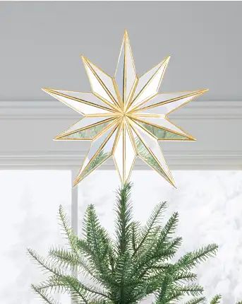 a christmas tree topper with a gold star hanging from it's centerpiece