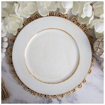 two white plates sitting on top of a marble counter next to flowers and other decorations