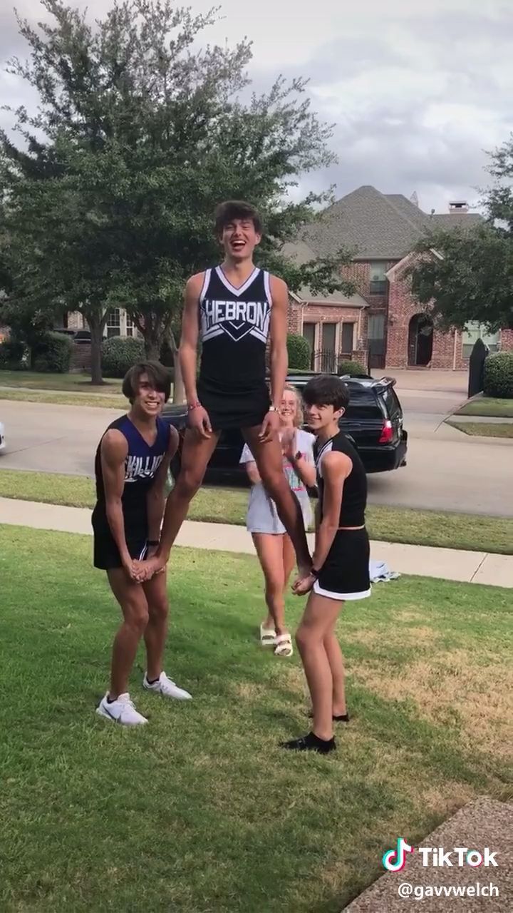 a group of young people standing on top of each other in front of a house