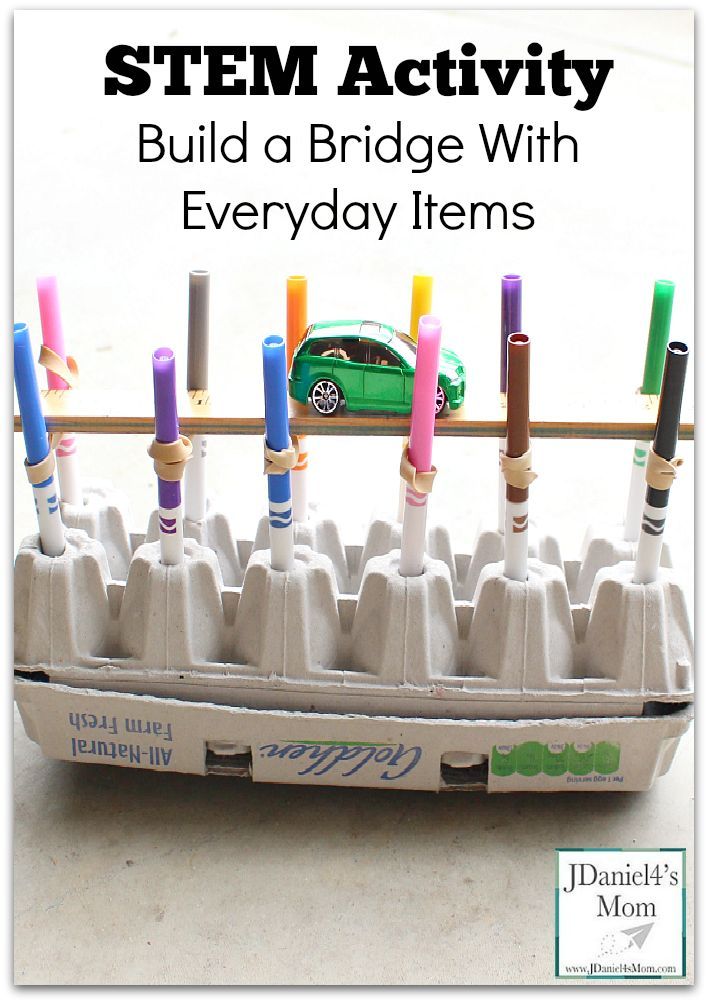 an egg carton filled with crayon sticks and a green car on top