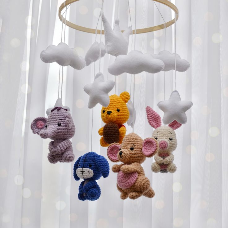 crocheted stuffed animals are hanging from a chandelier with white lights in the background