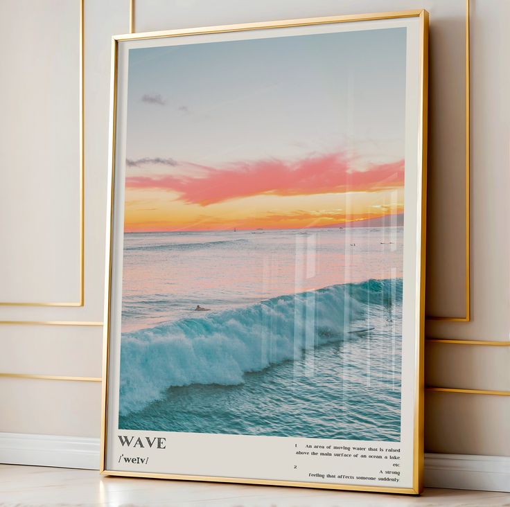 a framed photograph of the ocean with a sunset in the background