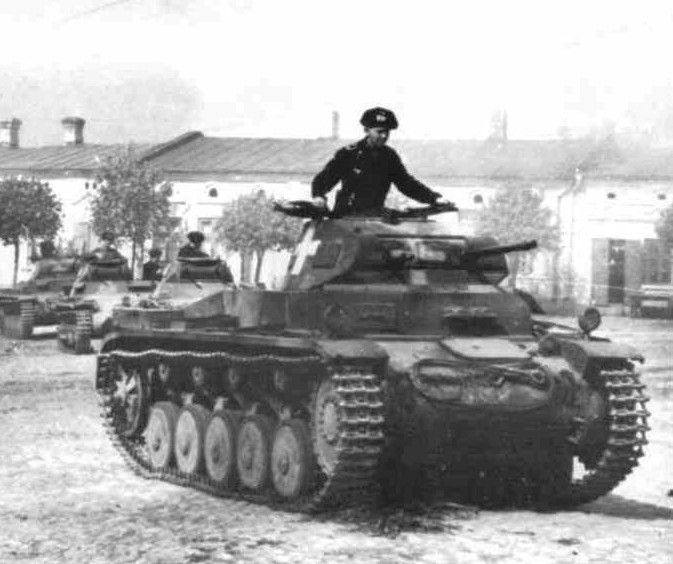 an old black and white photo of a man sitting on top of a tank