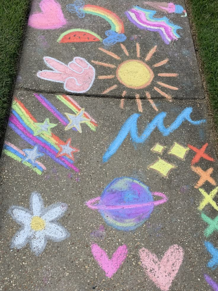 the sidewalk has chalk drawings on it and is decorated with flowers, sun, stars, planets