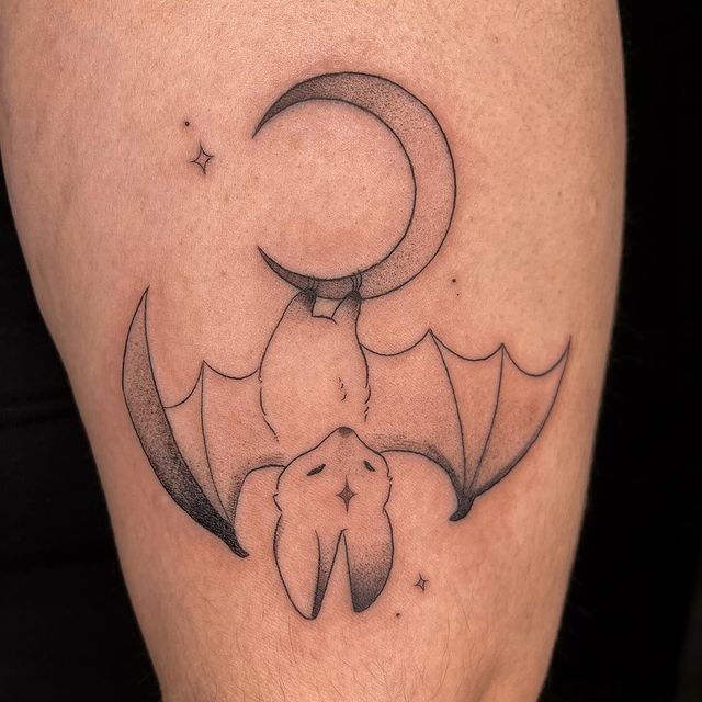 a bat and moon tattoo on the leg