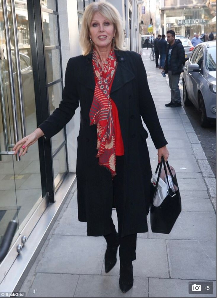 a woman is walking down the sidewalk with her hand out and holding two shopping bags