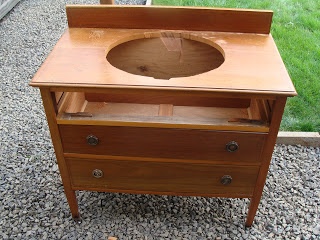 a wooden vanity with a mirror on top