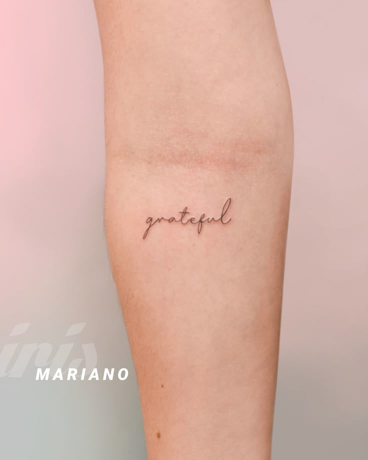 a woman's leg with the word grateful tattooed on her left side calf area