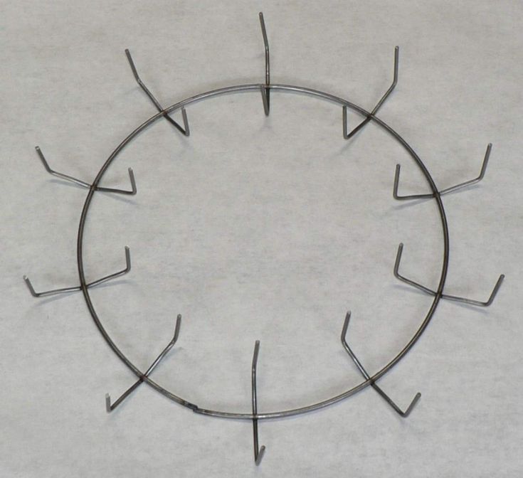 a circular metal object sitting on top of a white surface with several nails sticking out of it